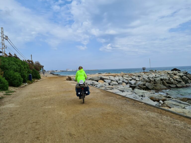 Fietser in regenjas langs de Middellandse Zee | Ev8 Valencia - Girona etappe 8